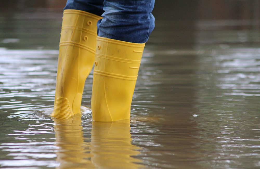 Mann mit Stiefeln bei Hochwasser